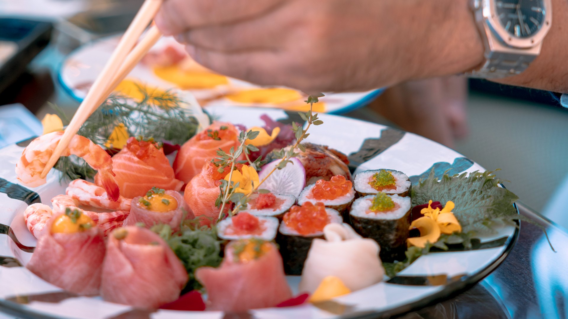 man eating sushi with chopsticks